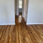 A hallway with wooden floors and white walls.