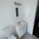 A bathroom with white walls and tile floors.