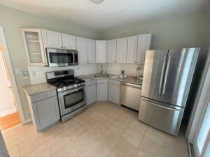 A kitchen with white cabinets and stainless steel appliances.