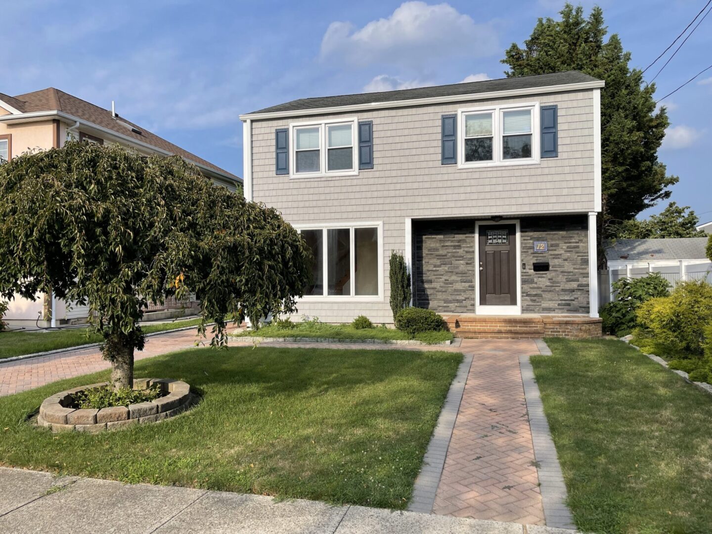 A house with a brick walkway and grass