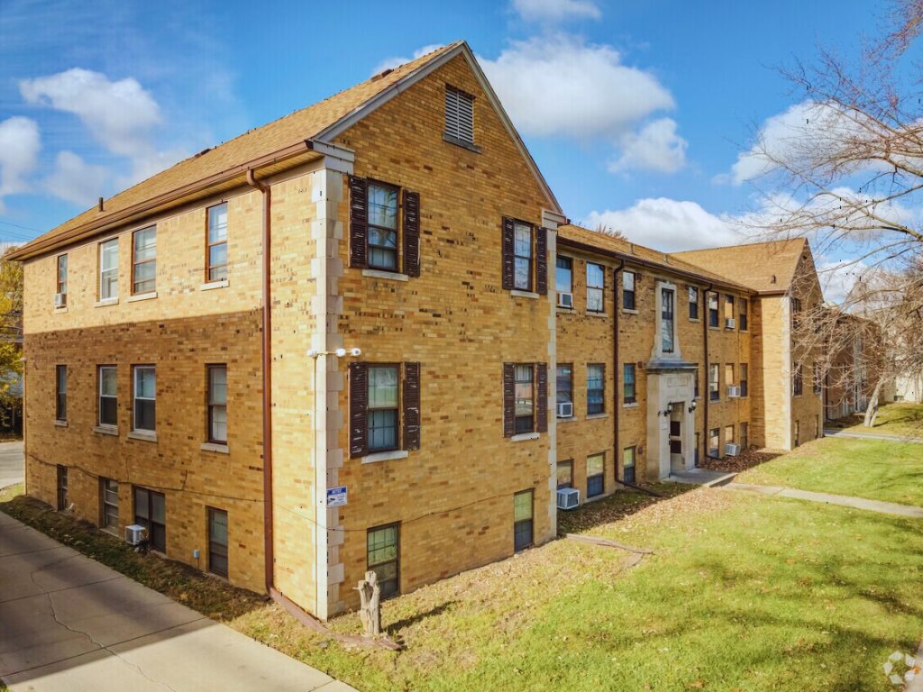 Brick apartment building under a blue sky.