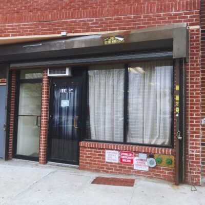 Brick storefront with glass door and curtains
