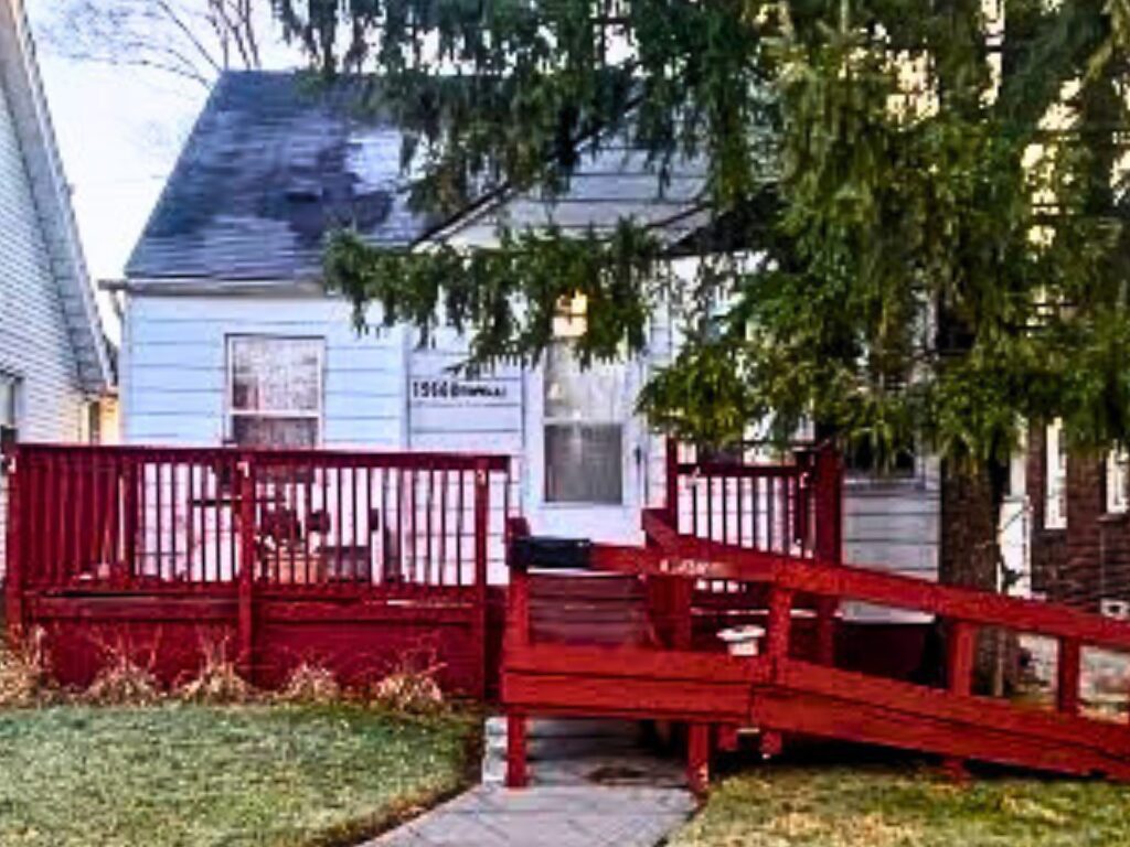 Small house with red ramp and deck.