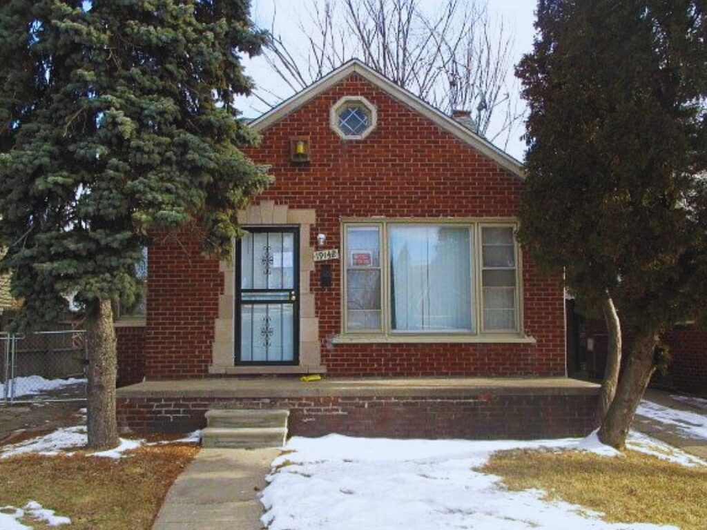 Brick house with snow-covered front yard.