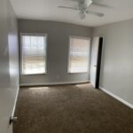 Empty room with carpet and ceiling fan.