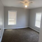 Empty room with carpet and ceiling fan.