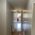 Hallway with wooden floor and open door.