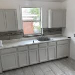 White kitchen with gray cabinets and sink.