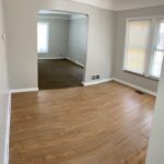 Empty room with wooden and carpet flooring.