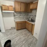 Small kitchen with wooden cabinets and tiles.