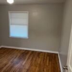 Empty room with wooden floor and window.
