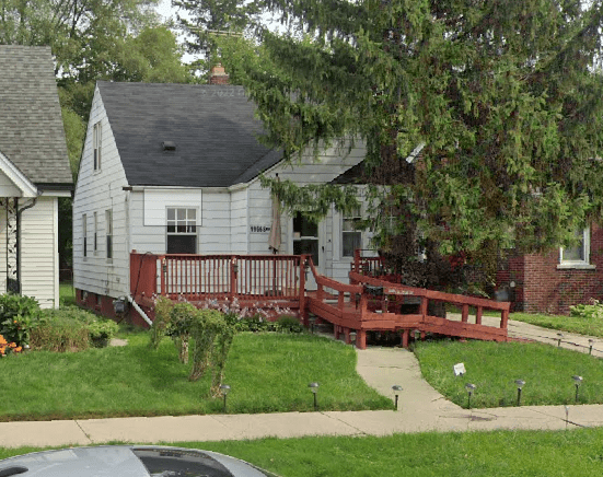 Small house with red ramp and porch.