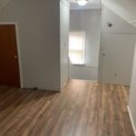 Empty room with wooden floor and window.