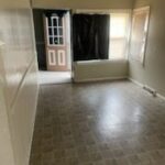 Empty room with tiled floor and windows.