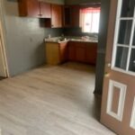 Small kitchen with wood cabinets and flooring.