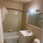 Small bathroom with tub and vanity.