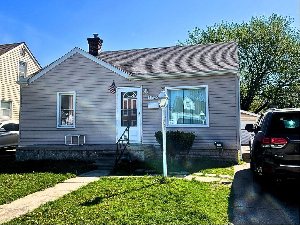 Small house with front yard and car.