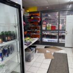 Small store interior with shelves and fridge.