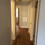 Hallway with wooden floor and multiple doors.